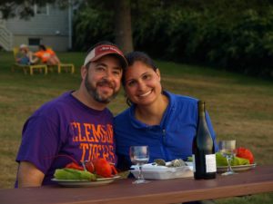 Couple sitting with lobster and wine at a park bench on coastal Maine