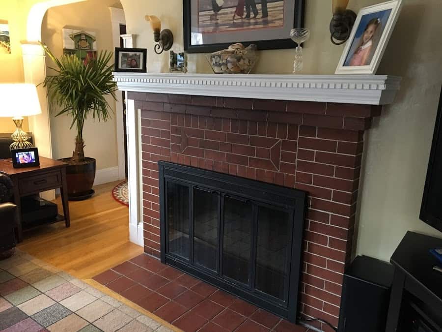 This used to be a ugly brass-plated fireplace door.  Sure I'd love a new one, but for $10 and a few hours over a weekend I transformed it into this more unstated black door. #blackfireplacedoor #upgradefireplacedoor #fireplacedoorchange #fireplacedoorpaint