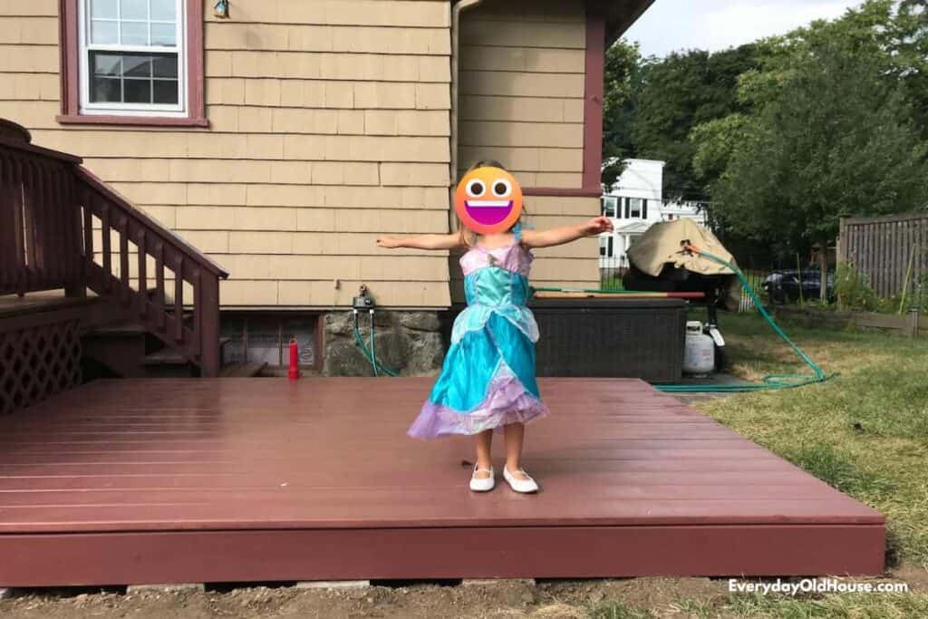 girl sanding on a completed DIY low or flating deck 