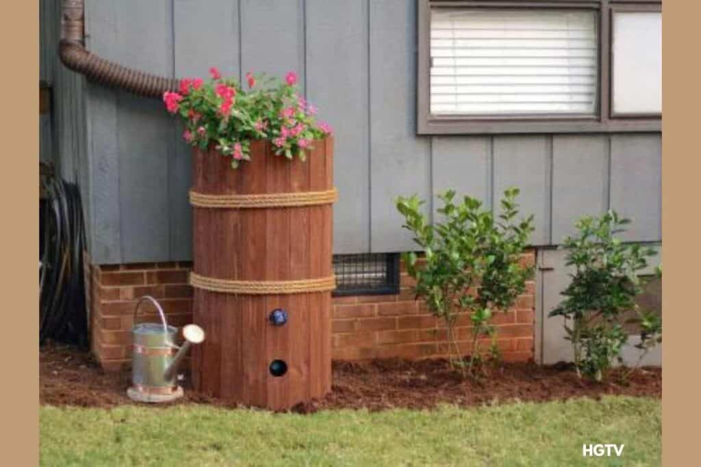 ugly blue rain barrel camoulaged by wooden planks. Tutorial and photo courtesy of HGTV