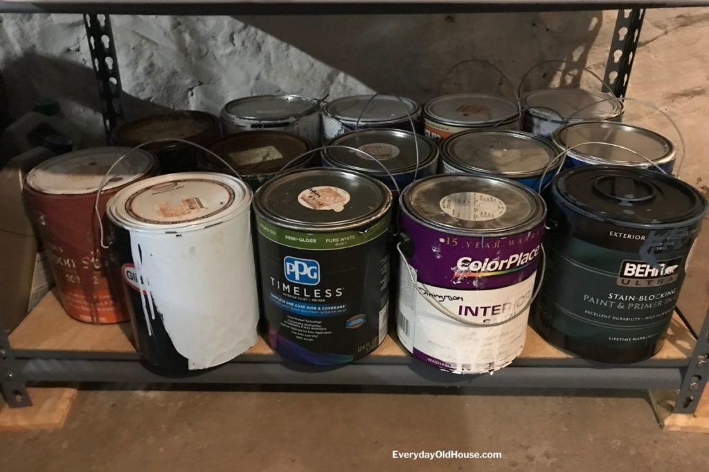 line of used paint cans in basement