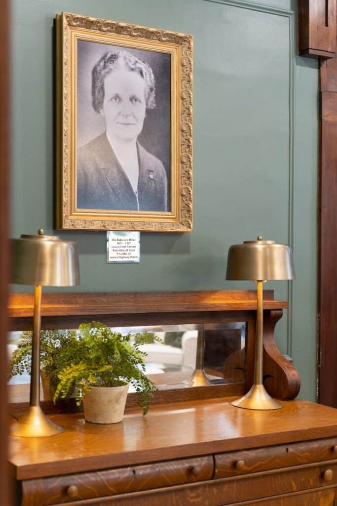 diningroom with historic green painted walls, wooden desk and photo of Ola Miller Babcock