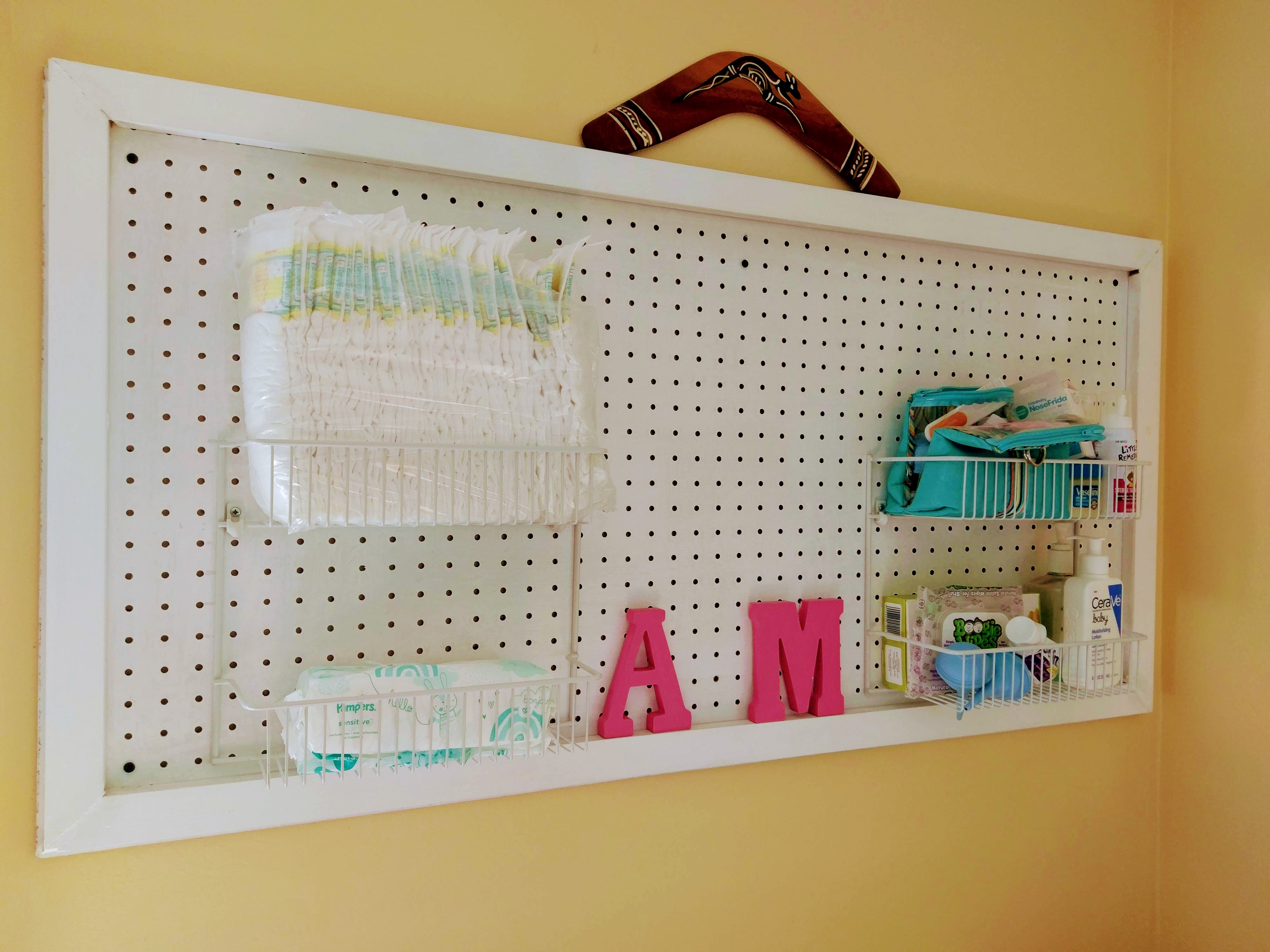 Pegboard used to make a wall-mounted diaper station #spacesaving #diaperstation #nurseryDIY