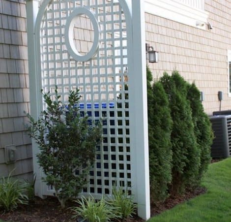 Privacy screen and evergreens to hide ugly rain barrel from street