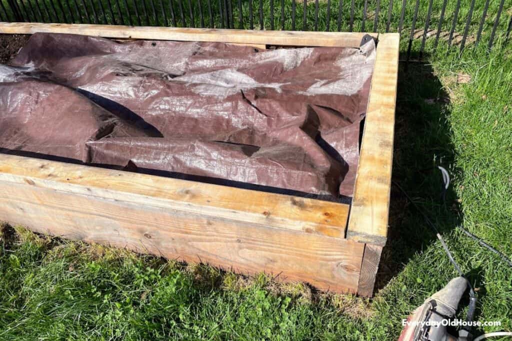 osoiled covered with tarp to cut down on sawdust entering garden bed