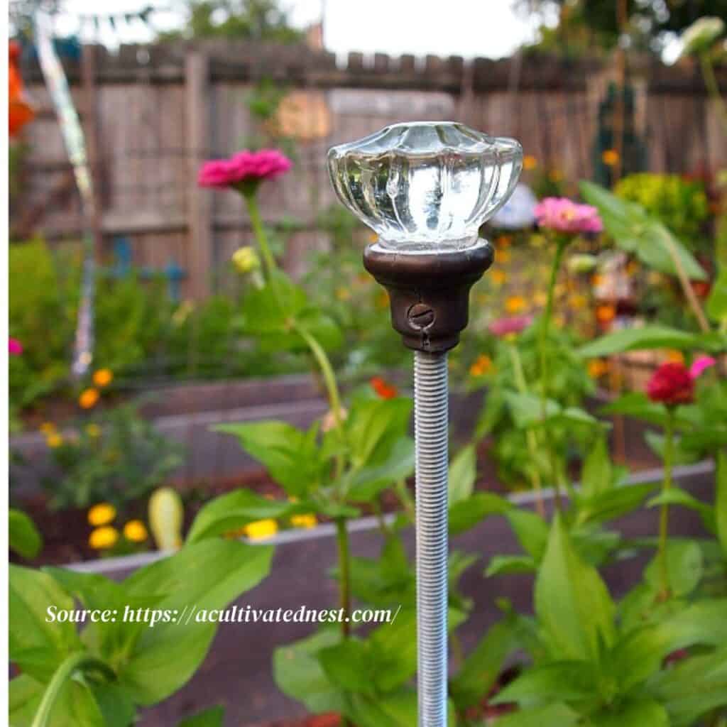Vintage glass doorknob repurposed as garden hose guide https://acultivatednest.com/