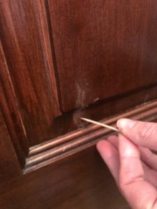 Apply wood putty with a toothpick to get in the grooves of wood panel for exterior door #minwax #woodputty #quickfix