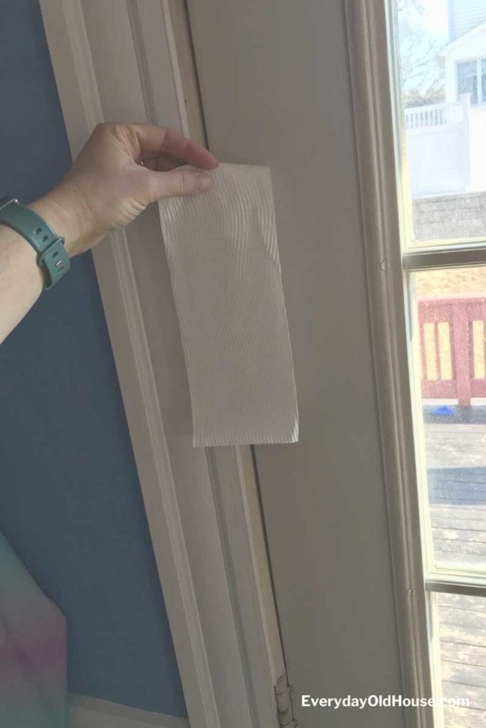 toilet paper hung over drafty door to detect leaks