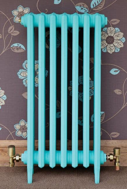 Beautiful example of inspiring and unique paint colors for cast iron radiators. Turquoise cast iron radiator compliments a purple floral wallpaper #interiordesign #interiordecortolove